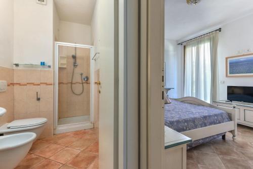 a bathroom with a bed and a toilet and a shower at Appartamenti Castle in Campo nell'Elba