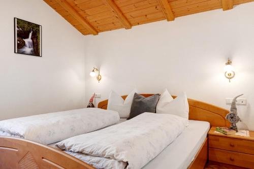 two beds in a room with white walls and wooden ceilings at Malsethhof in Villandro