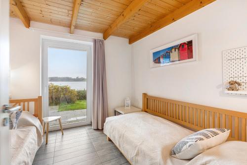 a bedroom with two beds and a large window at Brombeeruferhaus in Kosel