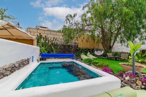 a swimming pool in a backyard with a garden at Oceania Villa A in Chayofa