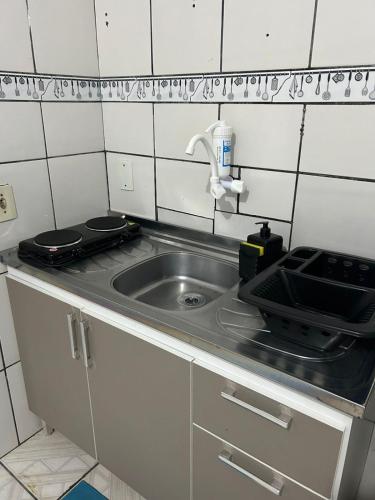 a small kitchen with a sink and a stove at Vila do Chaves Prof Girafales 15 in Itajaí