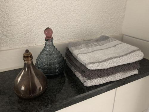 a bathroom counter with two glass vases and towels at Ferienwohnung Bäumchenblick in Müllheim