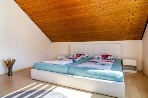 two beds in a room with a wooden ceiling at Fewo Georg in Pfullendorf