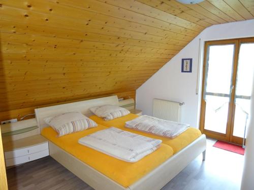 two beds in a room with a wooden ceiling at Ferienwohnung Zerlaut in Langenargen