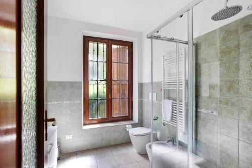 a bathroom with a toilet and a glass shower at Casa Tua - Avise in Avise