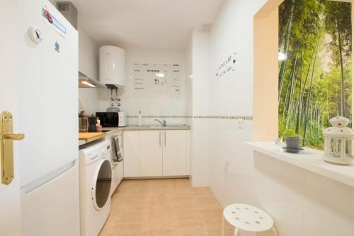 a white kitchen with a washer and dryer in it at Barlovento in Algarrobo