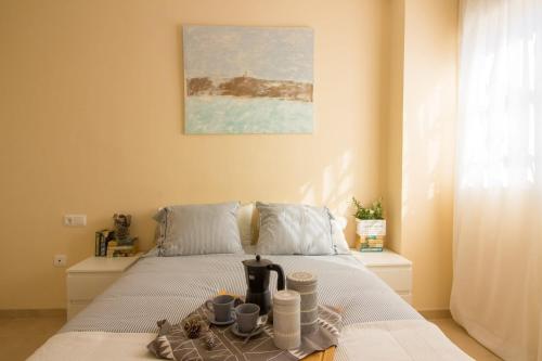 a bedroom with a bed with a tray with cups and a coffee maker at Barlovento in Algarrobo
