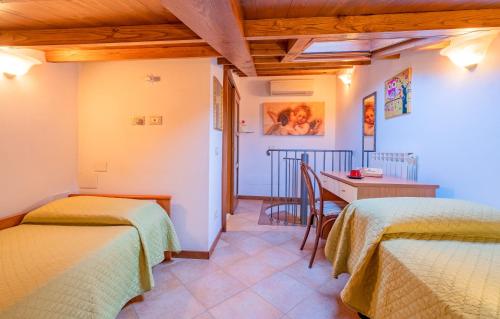 a room with two beds and a table with a tableablish at Casina La Torretta - By The Walls in Lucca