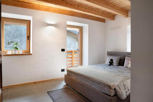 a bedroom with a bed and a window at Bio Maso Nido Verde in Frassilongo