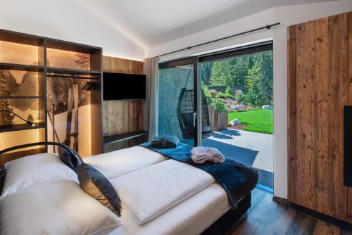 a bedroom with a bed and a large window at Chalet Ski in Selva di Val Gardena