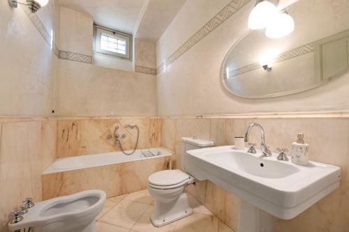 a bathroom with a sink and a toilet and a tub at Viasambuco in Iseo