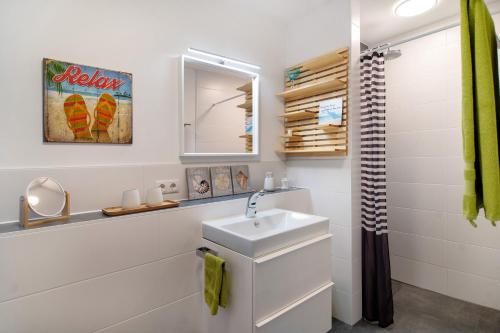 a white bathroom with a sink and a mirror at Ferienwohnung mit eigenem Eingang in Deggenhausertal