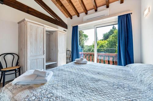 a bedroom with a large bed and a large window at Al Segnavento Fasanella in Toscolano Maderno