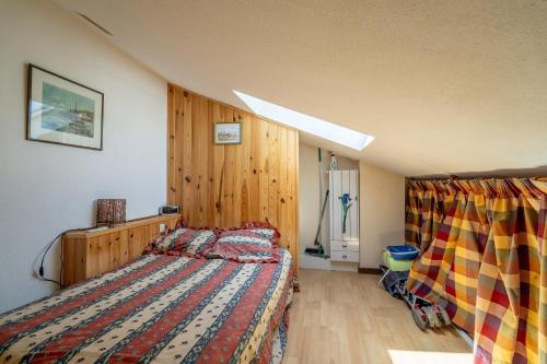 a bedroom with a bed with a colorful comforter at Les Eaux Vives 1 in Fleury