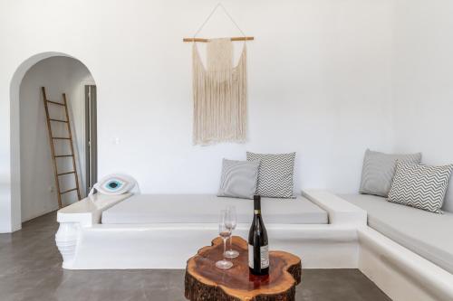 a white living room with a white couch and a bottle of wine at Ow Andros Suite 2,Private Whirlpool in Andros