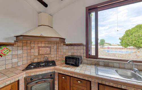 a kitchen with a stove and a sink and a window at Villa Parisi con piscina in Syracuse