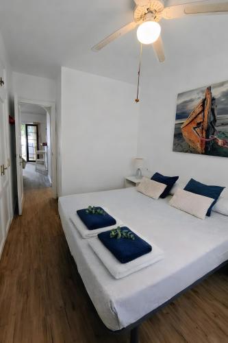 a bedroom with a large white bed with blue pillows at Binimar - Cala en Porter in Cala en Porter