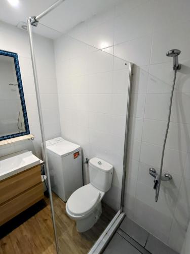 a white bathroom with a toilet and a shower at Binimar - Cala en Porter in Cala en Porter