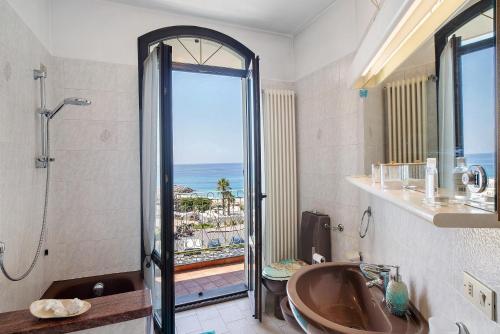 a bathroom with a tub and a shower with a view of the ocean at Wonderful flat by sea chez Monique in Bordighera