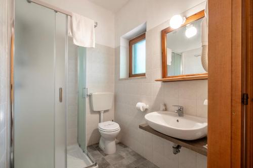 a bathroom with a toilet and a sink and a mirror at Rosaspina - Appartamento 4 in Capalbio