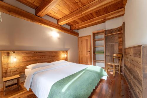 a bedroom with a large bed and a wooden ceiling at Civico 11 in Marmora