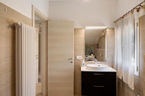 a bathroom with a sink and a mirror at Mansarda Albero Verde con Piscina in Casanova Lerrore