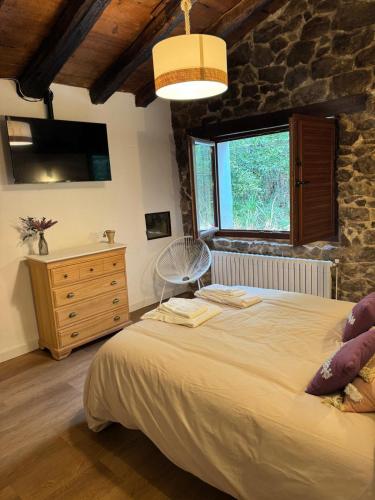 a bedroom with a large bed and a stone wall at Casa Eider in Rucandio