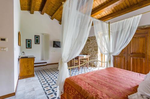a bedroom with a canopy bed and a table at Arcaloro Resort Rooms in SantʼAngelo di Brolo