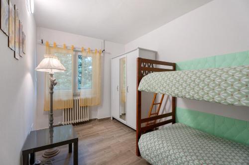a bedroom with a bunk bed and a lamp at Sweet Home Apartments Bambù in Arona