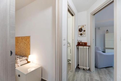 a small room with a bed and a table and a lamp at Sweet Home Apartments Bambù in Arona