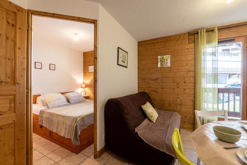 una camera da letto con un letto, una sedia e un tavolo di Ty Aravis a La Giettaz