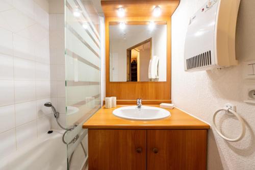 un bagno con lavandino, specchio e vasca di Ty Aravis a La Giettaz