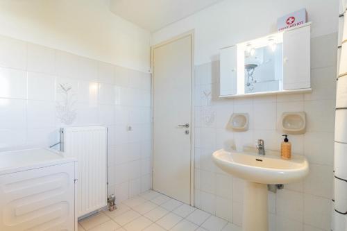 a white bathroom with a sink and a shower at Olivea Apt 1 in Acharavi