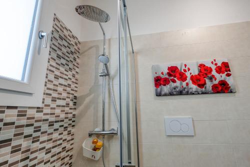 a bathroom with a shower with a painting of red flowers at Meravigliosalento in Squinzano