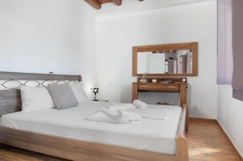 a bedroom with a white bed with a mirror at Nicolas House 1 in Rakhídhion