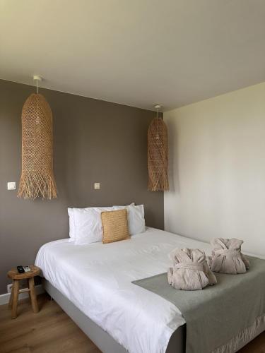 a bedroom with a white bed with two pillows on it at Le Wellness des alpagas in Huy