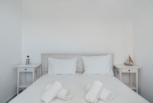 a white bed with white pillows and two tables at Nicolas House 3 in Rakhídhion