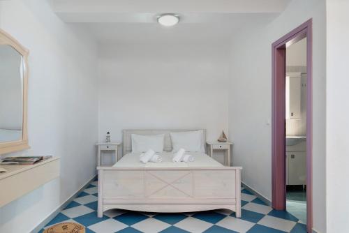a bedroom with a white bed and a blue and white floor at Nicolas House 3 in Rakhídhion
