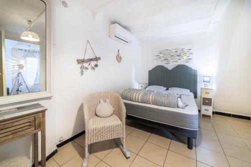 a bedroom with a bed and a chair and a mirror at Maison type Canetoise prox plage in Canet-en-Roussillon