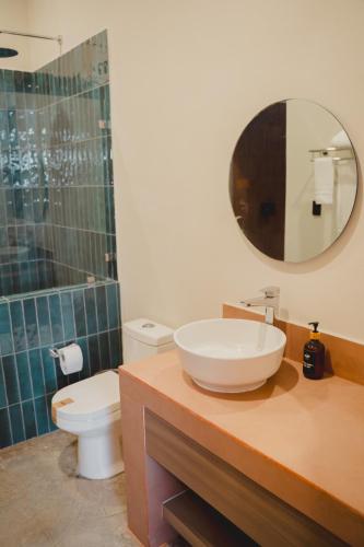 a bathroom with a sink and a toilet and a mirror at Hotel Calma Celesti in Perihuete
