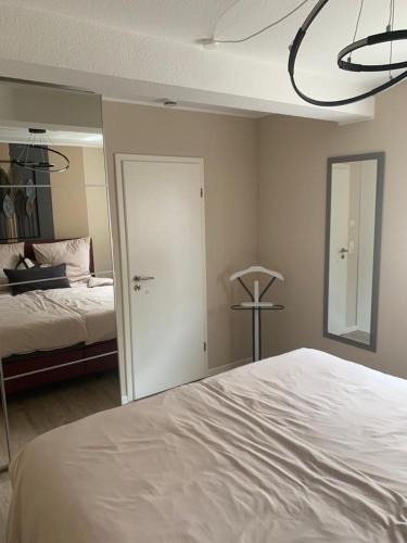 a bedroom with a white bed and a mirror at Gemütliche Wohnung in Ortsrandlage in Rüdesheim am Rhein