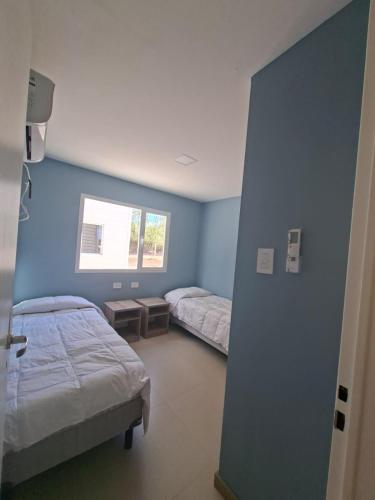 a hospital room with two beds and a window at El Portal Los Álamos in Rincon de los Sauces