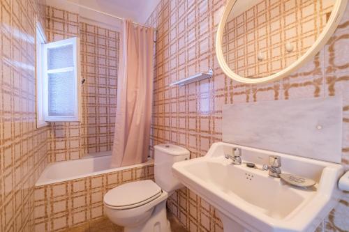 a bathroom with a toilet and a sink and a mirror at Apartamento las Palmeras 1 in Benicarló