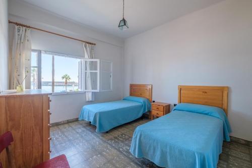 a bedroom with two beds and a window at Apartamento las Palmeras 1 in Benicarló