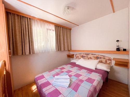 a bedroom with a bed with a colorful blanket at Le sorgenti - Mobile Home 46 in Palazzuolo sul Senio