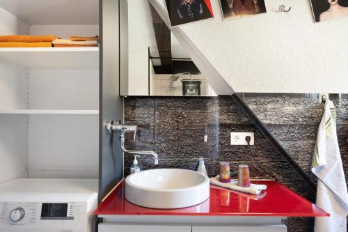 a bathroom with a sink on a red counter at Atelier-Loft im Hübschental in Gütenbach