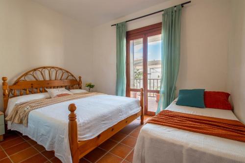 a bedroom with two beds and a window with a view at Pentavano White House in Isola Rossa