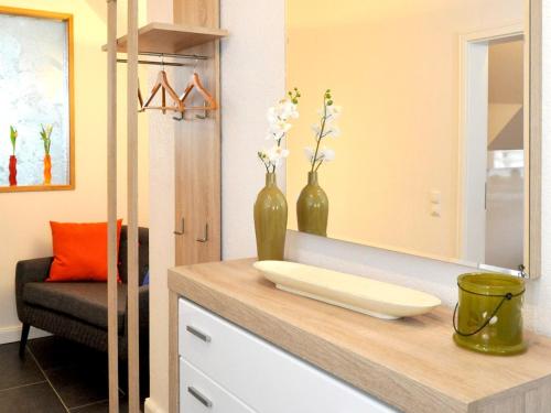 a bathroom with a counter with two vases and a mirror at Ferienwohnung Bock Feldmannshof in Drolshagen