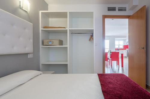 a bedroom with a white bed and a red rug at S23 Sa Caleta in Lloret de Mar