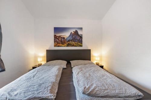a bedroom with two beds and a painting on the wall at Haus Zum Stumpfen Turm mit Sauna in Morbach